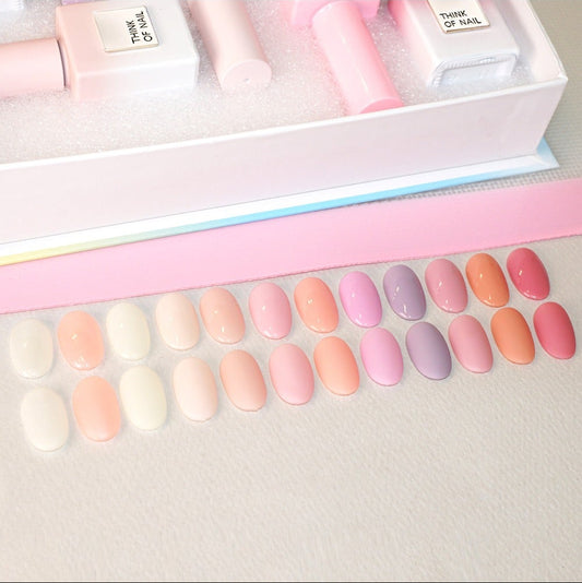 Nail polish collection with pastel shades and packaging on a white background
