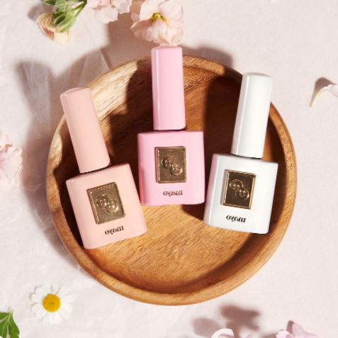 Three nail polish bottles on a wooden tray with flowers and text in the background